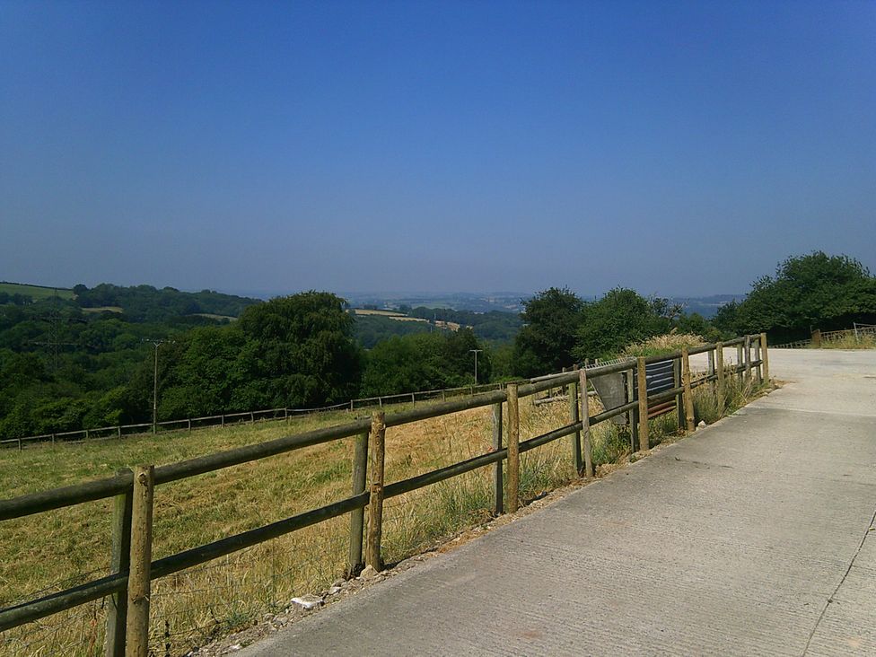 An outdoor scene with a road and fence in the countryside at Cider House Hawkchurch