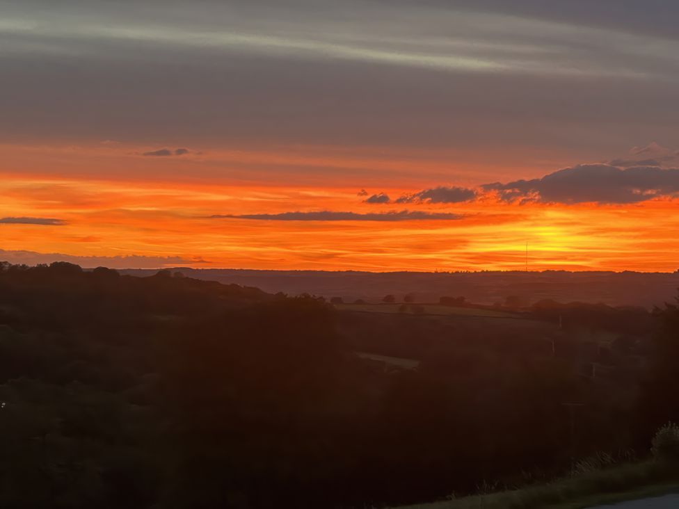 A sunset view over hills and trees at Cider House in Hawkchurch