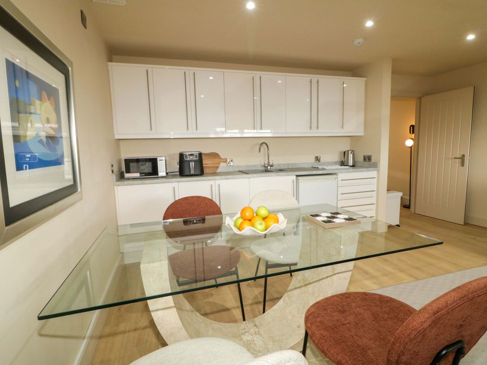 A kitchen with a glass table and chairs at Apartment 2 in Derry