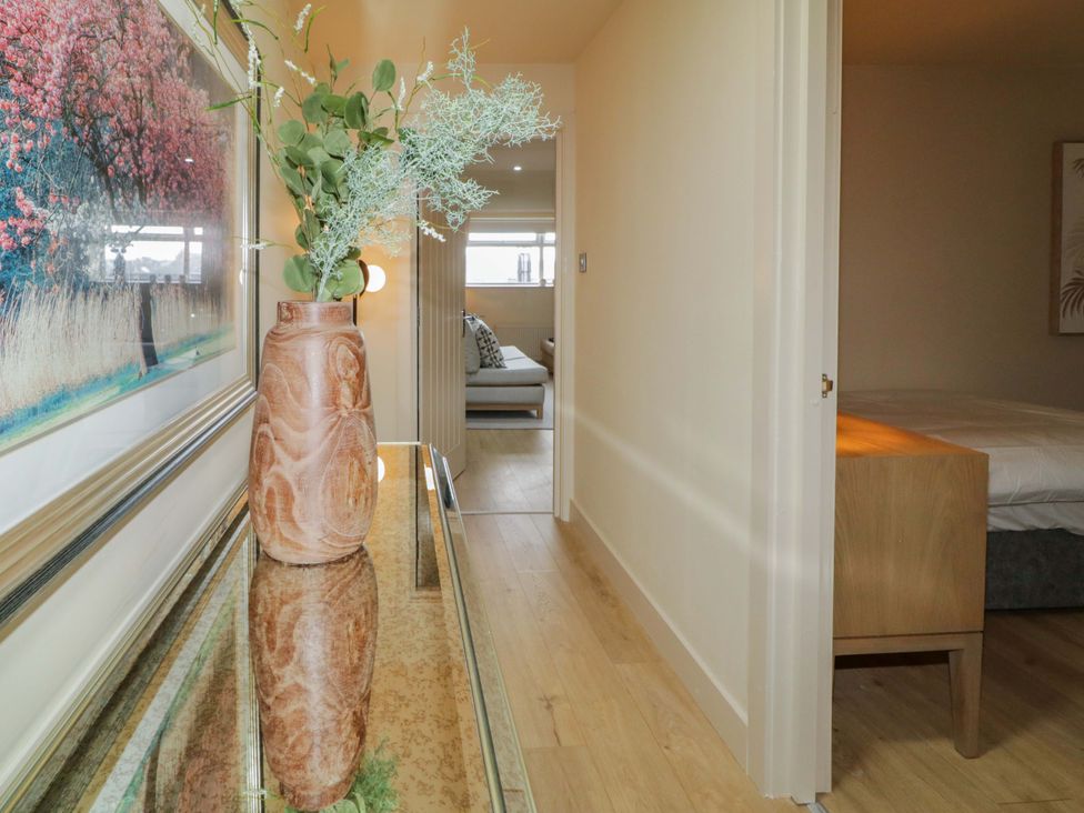 A hallway with a plant in a vase and doors leading to rooms at Apartment 2 in Derry