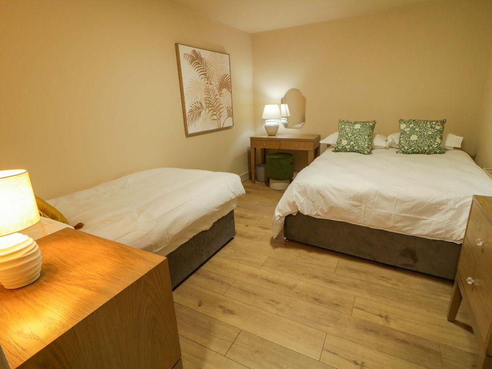 A bedroom with two beds, a nightstand, and decorative wall art at Apartment 2 in Derry