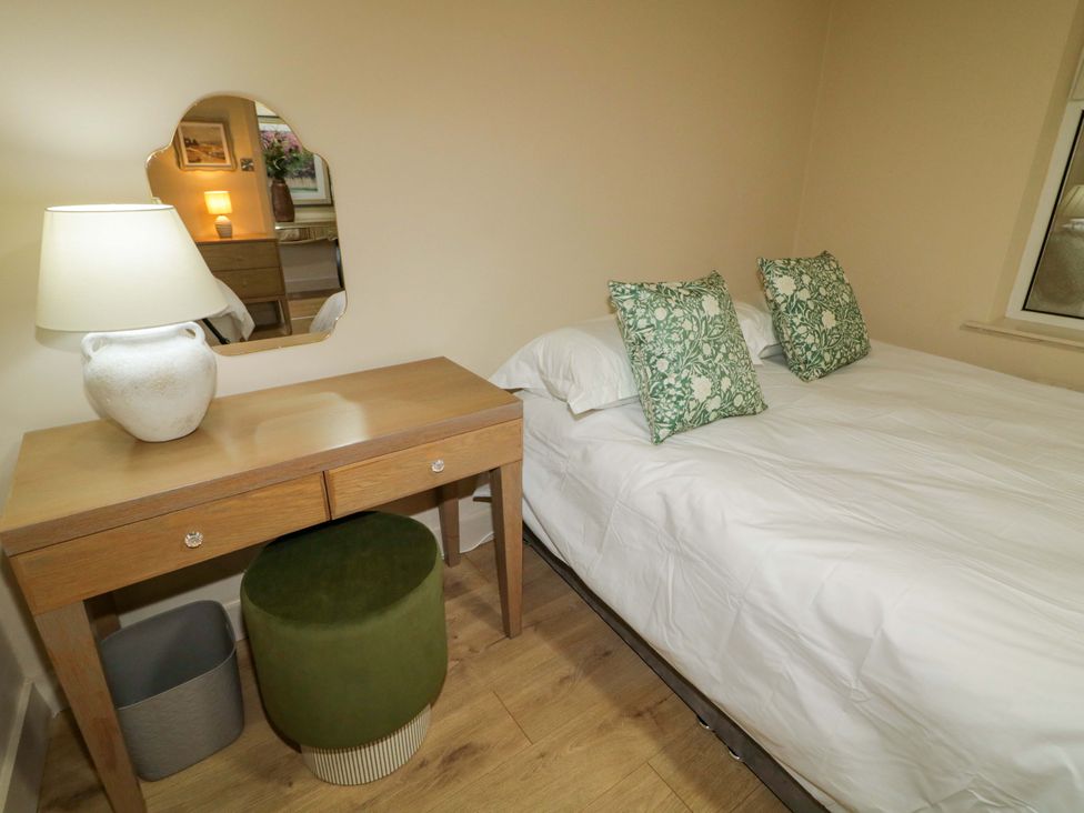 A bedroom with a bed, bedside table, lamp, and mirror at Apartment 2 in Derry