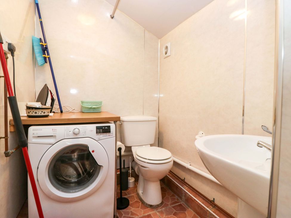 A bathroom with a washing machine and toilet at Tethera in Ennerdale
