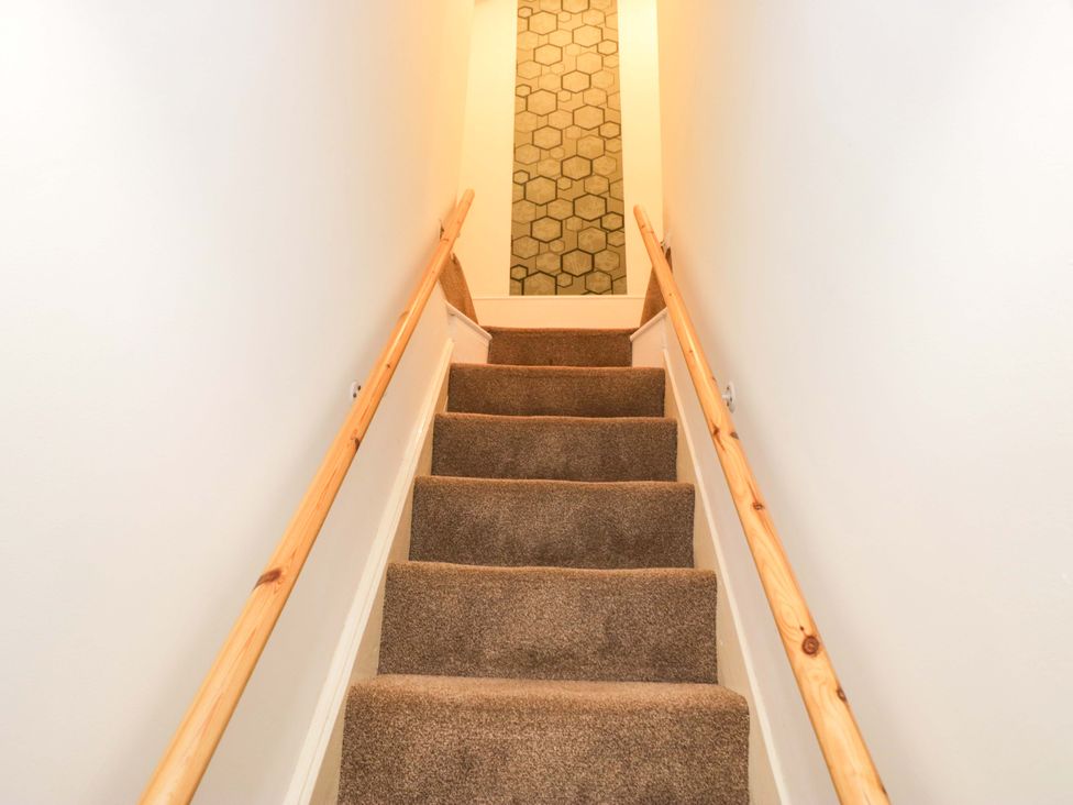 A staircase with carpet and a handrail at Tethera in Ennerdale