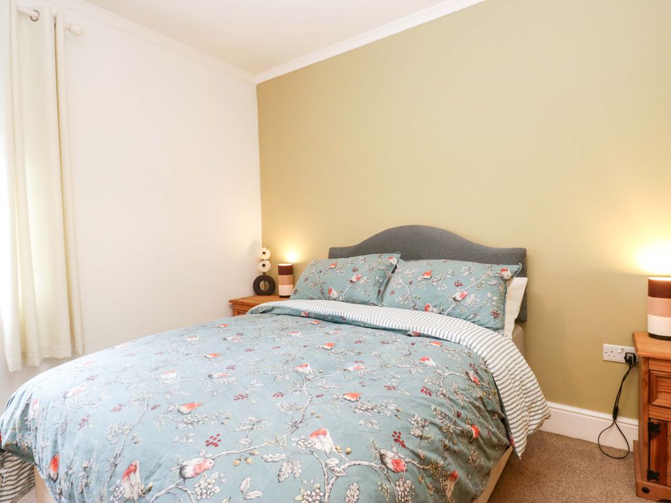 A bedroom with a bed and bedside tables at Tethera in Ennerdale