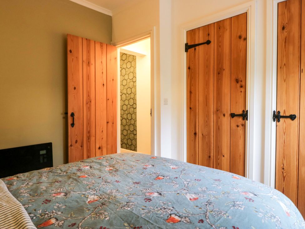 A bedroom with wooden doors and a bed at Tethera in Ennerdale