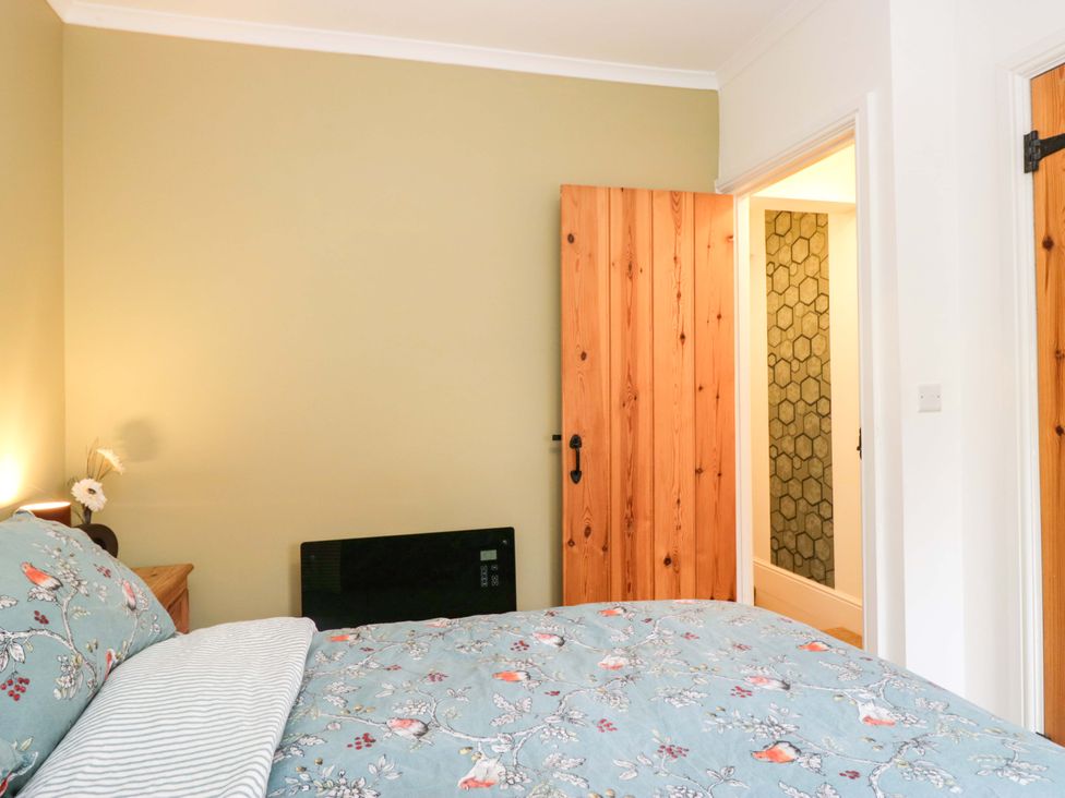 A bedroom with a bed and wooden door at Tethera in Ennerdale