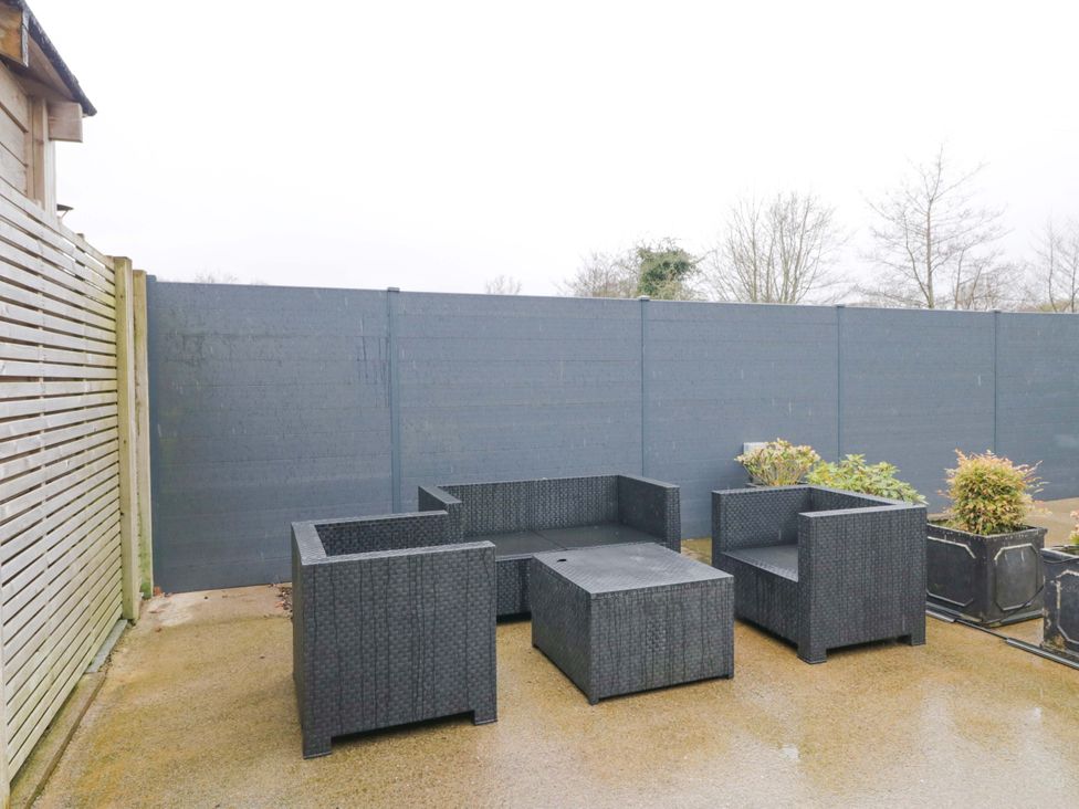 A sitting area with a table and potted plants at Tethera in Ennerdale