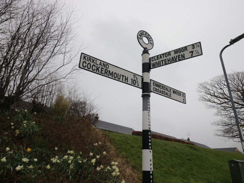 A directional signpost indicating Kirkland, Cockermouth, Cleator Moor, and Whitehaven in Ennerdale