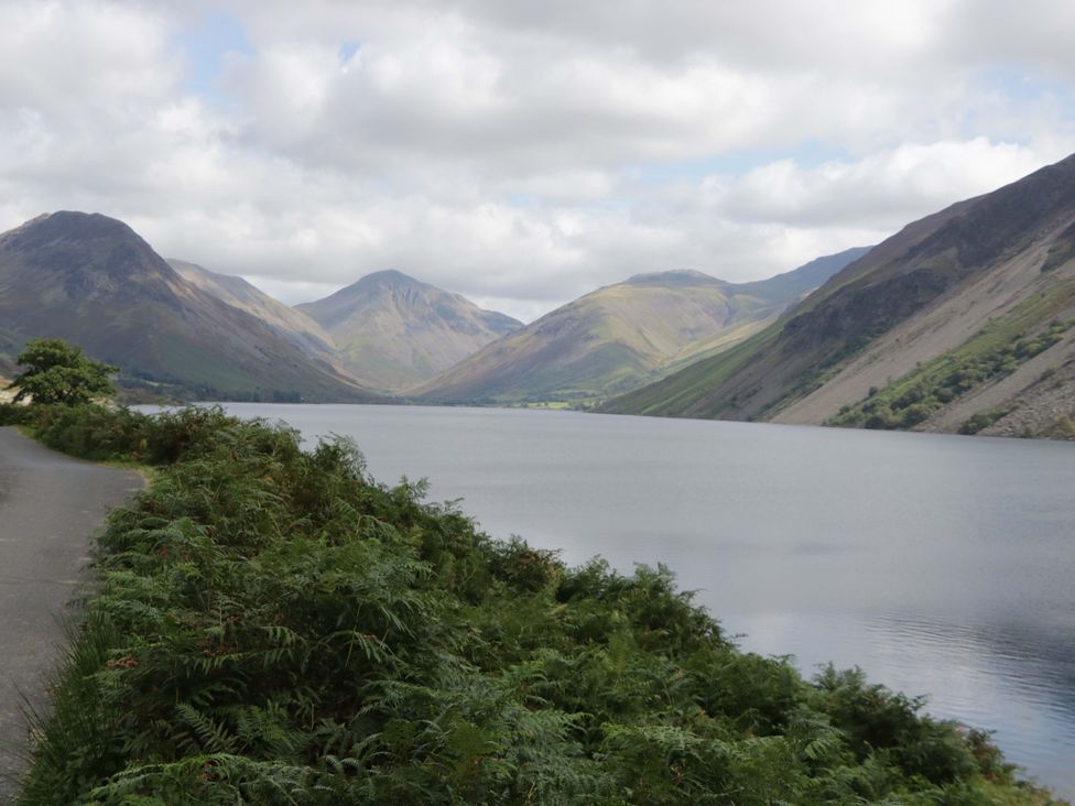 A lake surrounded by mountains and a road at Tethera in Ennerdale