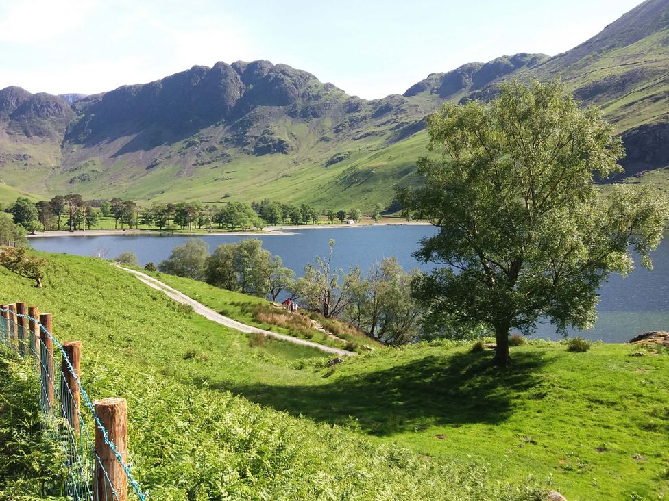 A view of a lake surrounded by hills and trees at Tethera Ennerdale