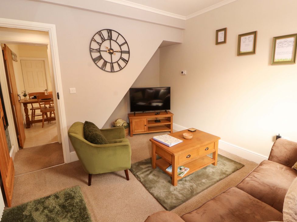 A living room with a sofa, coffee table, and television at Tethera in Ennerdale