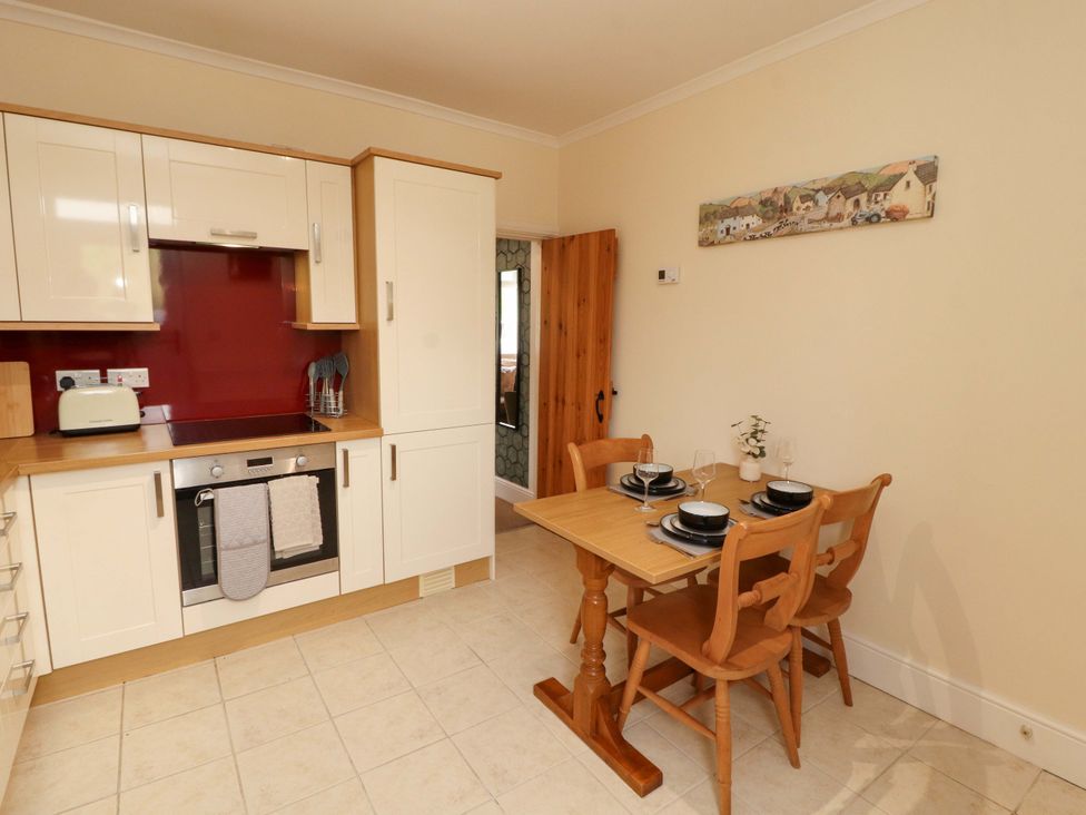 A kitchen with a dining table and chairs at Tethera in Ennerdale