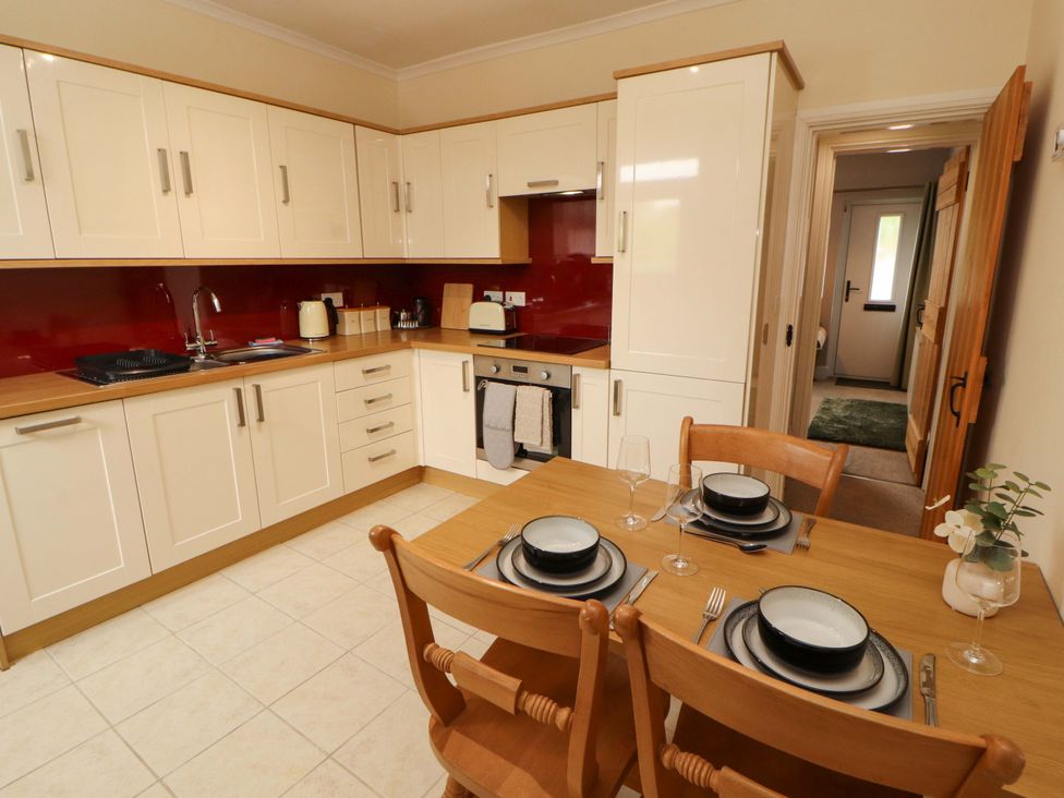 A kitchen with a dining table and chairs at Tethera in Ennerdale