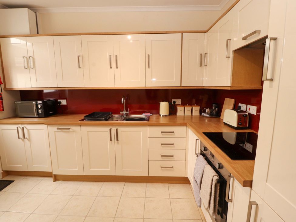 A kitchen with cabinets, microwave, sink, kettle, and toaster at Tethera in Ennerdale
