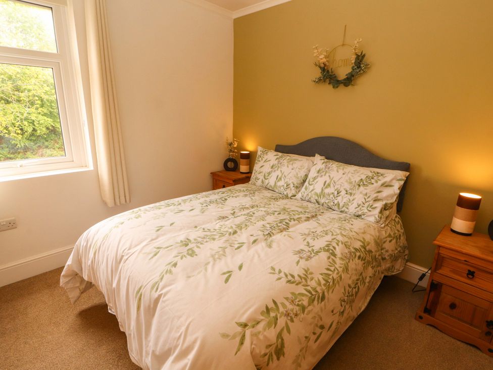 A bedroom with a bed and bedside tables at Tethera in Ennerdale