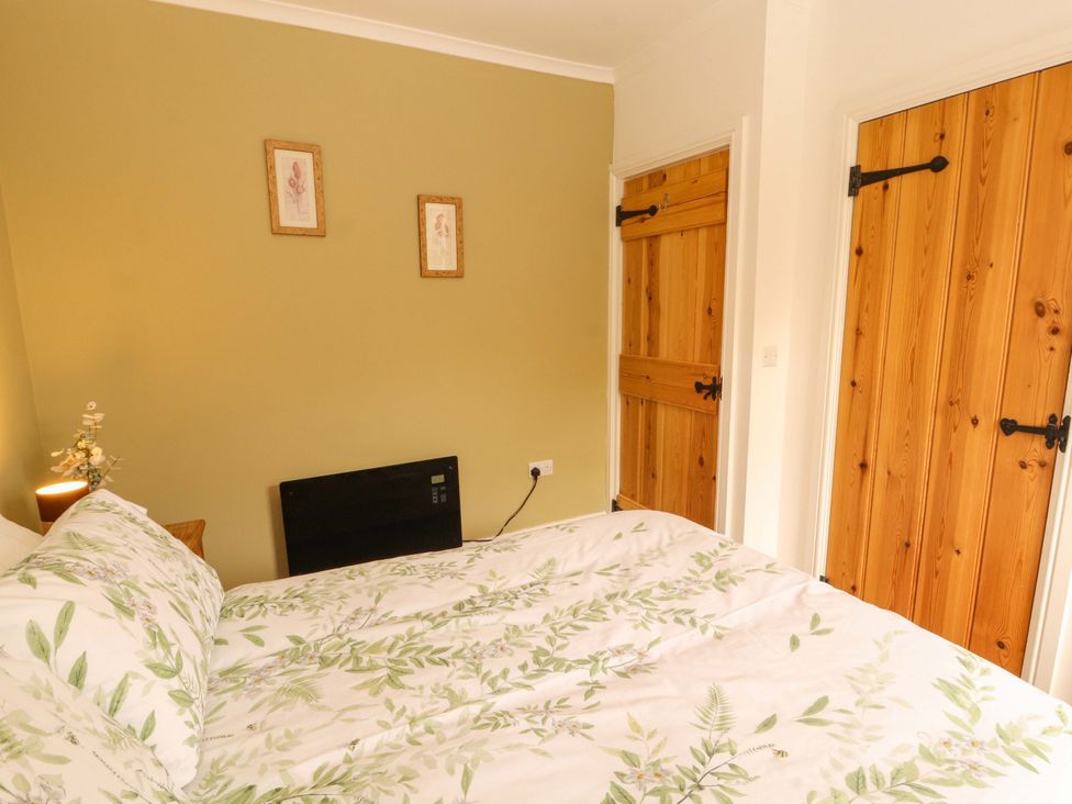 A bedroom with a bed and doors at Tethera in Ennerdale