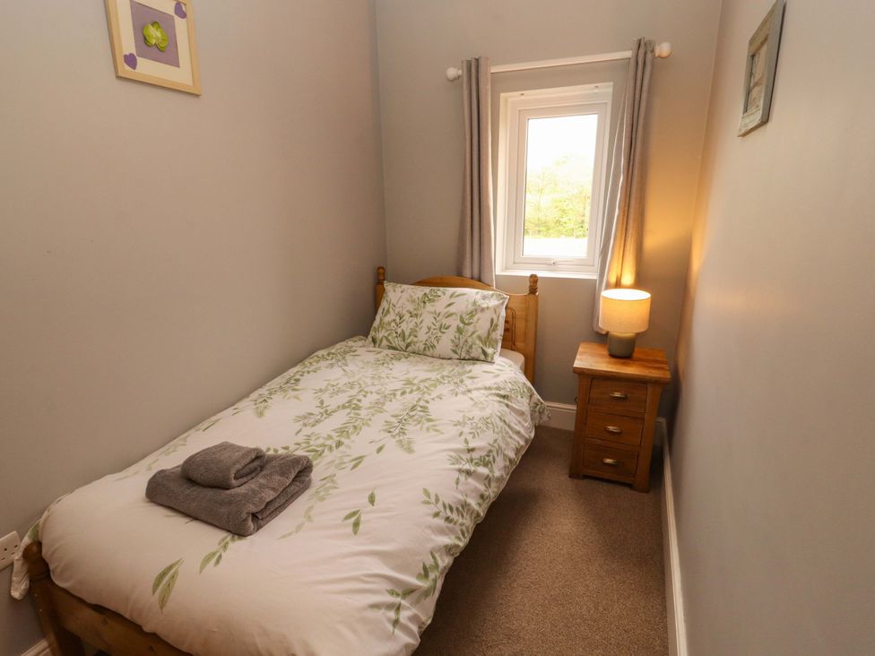 A bedroom with a single bed and a bedside table at Tethera in Ennerdale