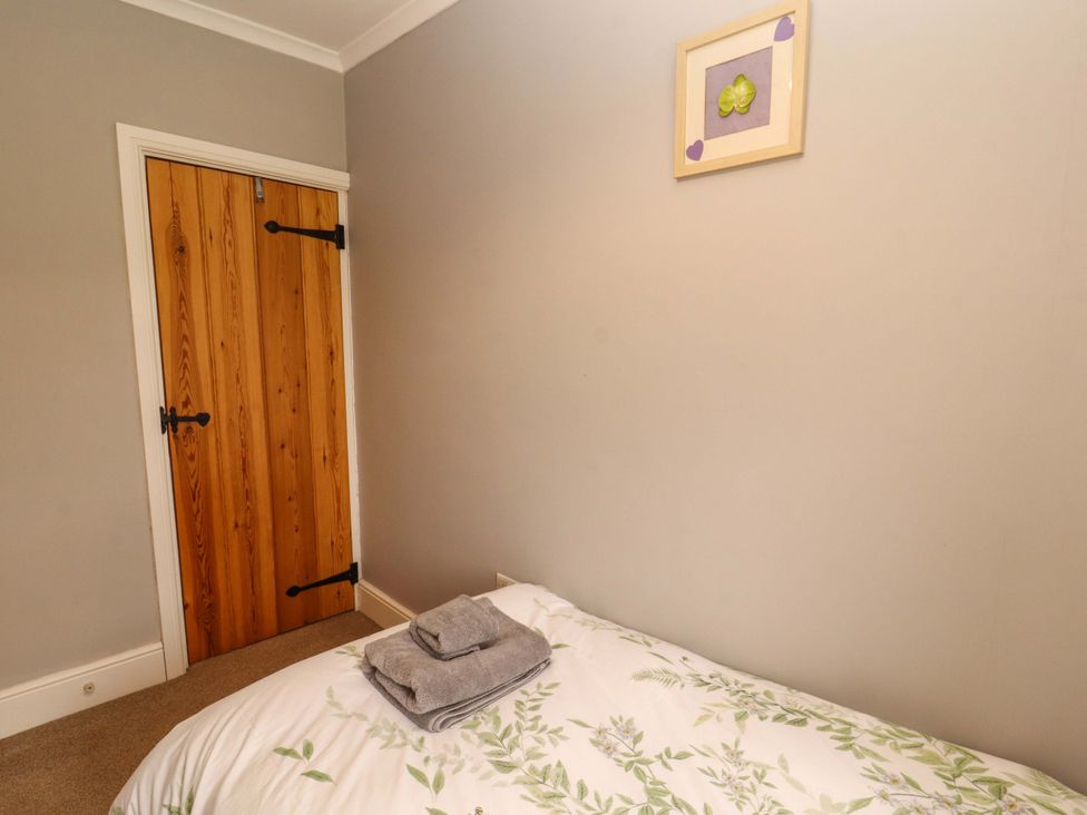 A bedroom with a bed and towels at Tethera in Ennerdale
