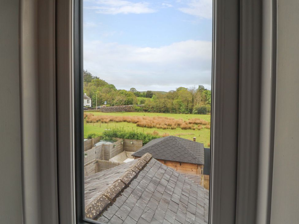 A view from a window overlooking a field and rooftops at Tethera in Ennerdale