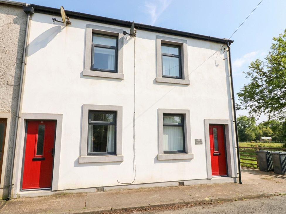 A building exterior with windows and red doors at Tethera in Ennerdale