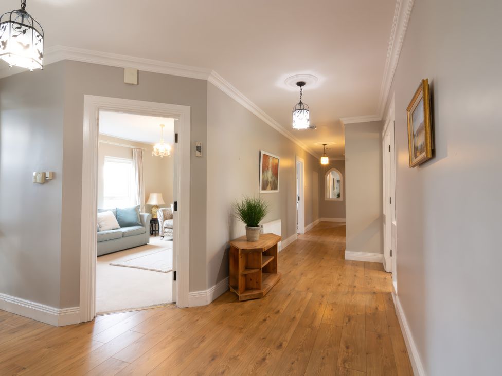 A hallway with a console table and chandelier at An Grianan Getaway in Burt