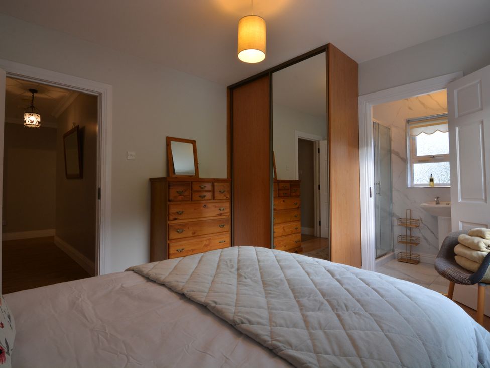 A bedroom with a bed and dresser with mirror at An Grianan Getaway Burt