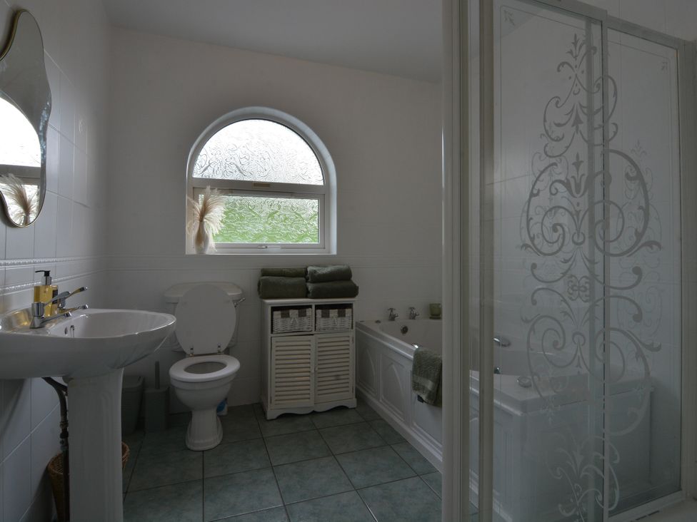 A bathroom with a shower and bathtub at An Grianan Getaway in Burt