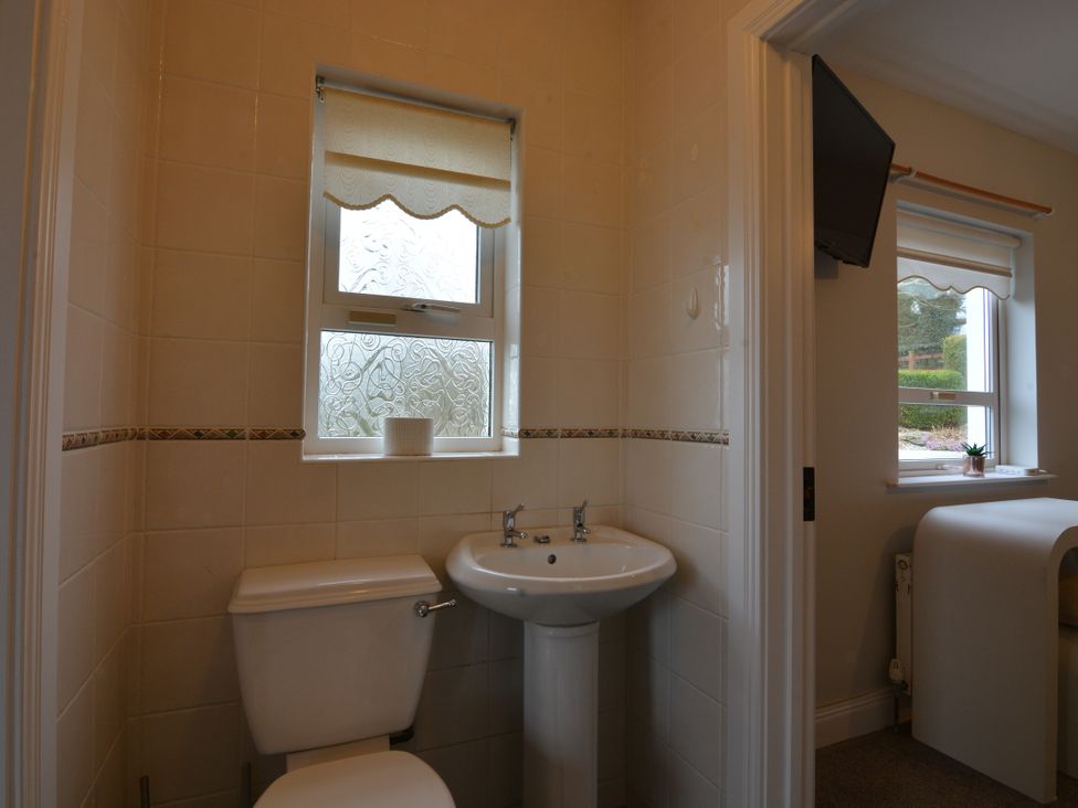 A bathroom with a toilet and sink at An Grianan Getaway in Burt