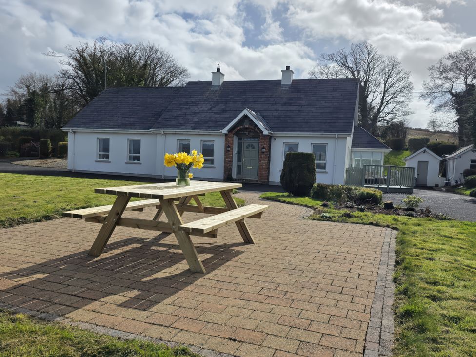 A house with a picnic table and flowers at An Grianan Getaway in Burt