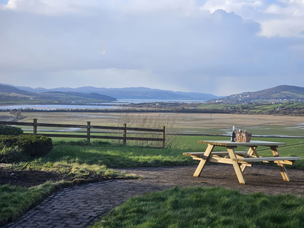 An outdoor area with a picnic table overlooking a field at An Grianan Getaway in Burt