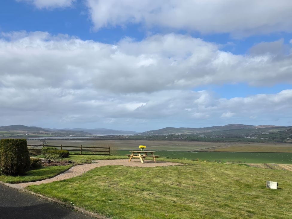 A garden with a table and flowers at An Grianan Getaway in Burt