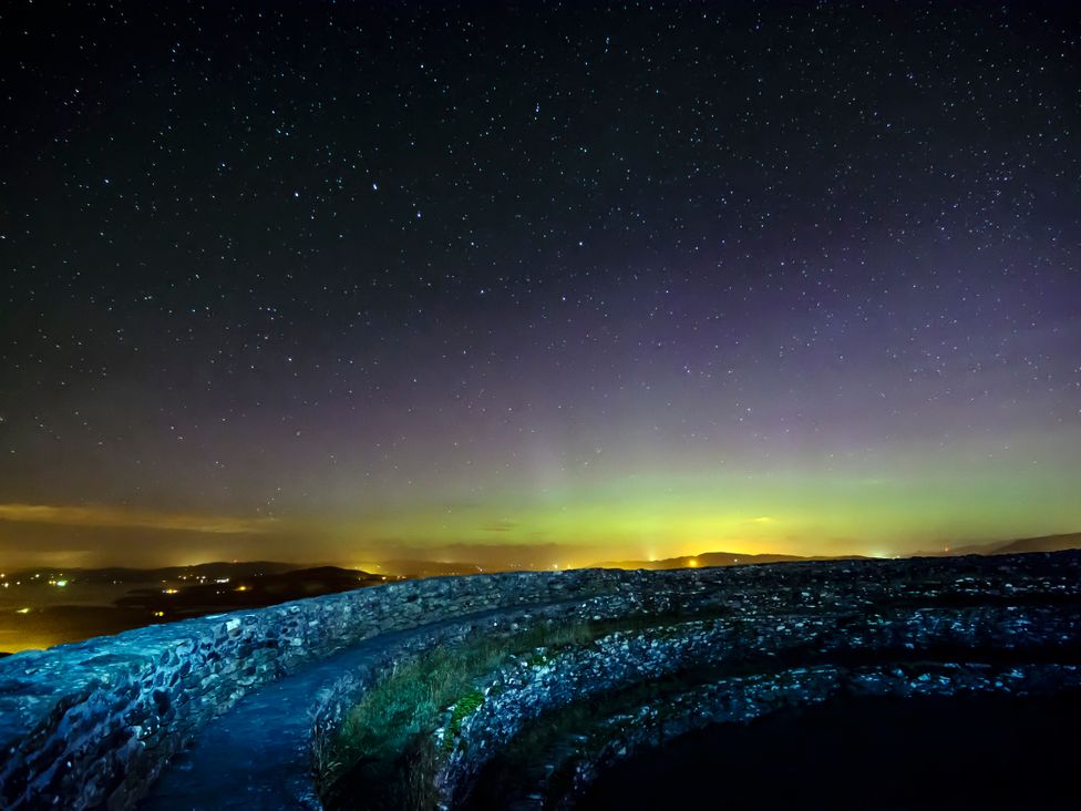 A night sky with stars and distant lights at An Grianan Getaway in Burt