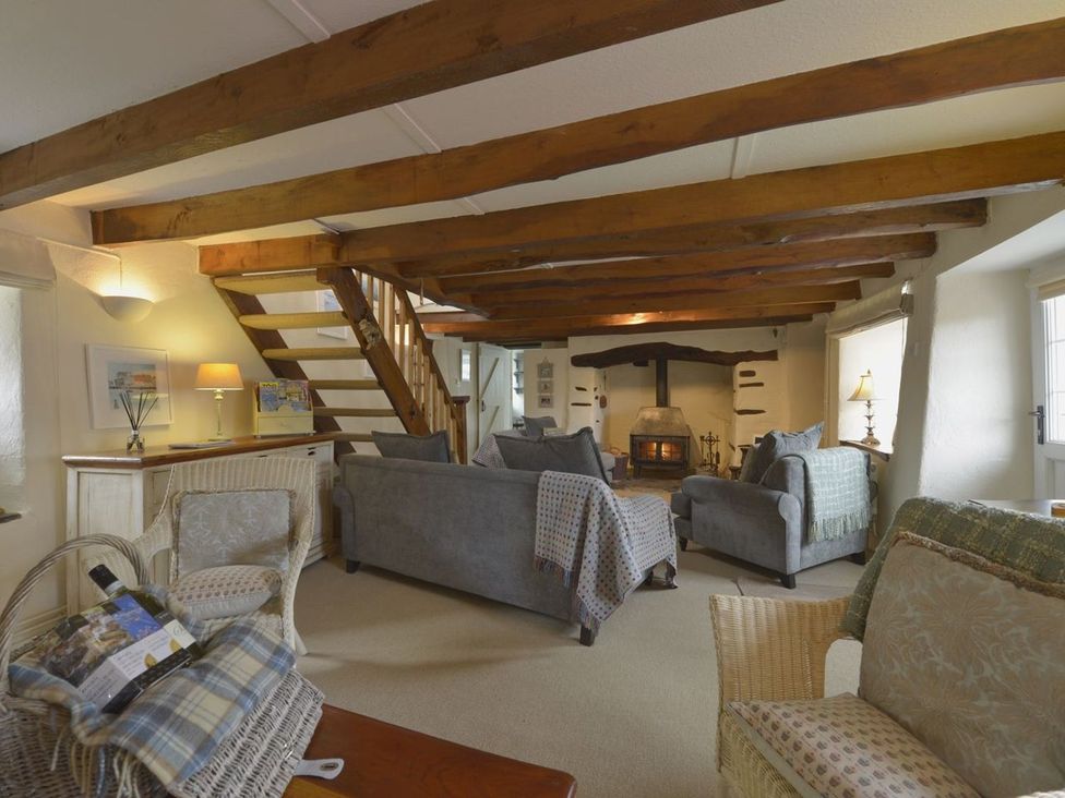 A living room with sofa and fireplace at Mays Cottage in Wadebridge