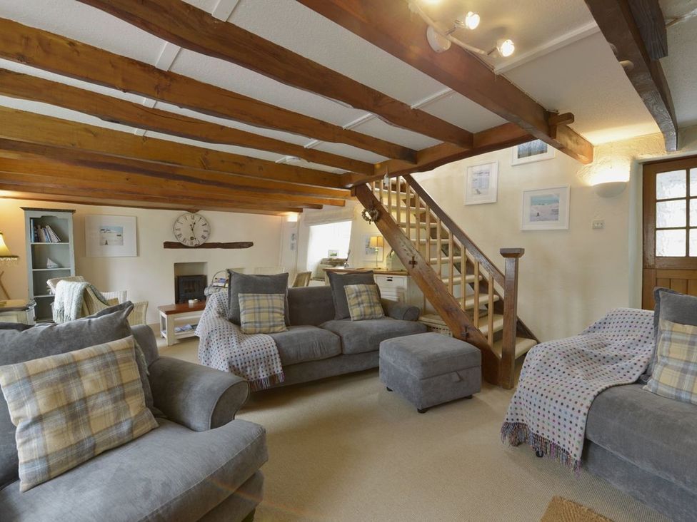 A living room with furniture and a staircase at Mays Cottage in Wadebridge