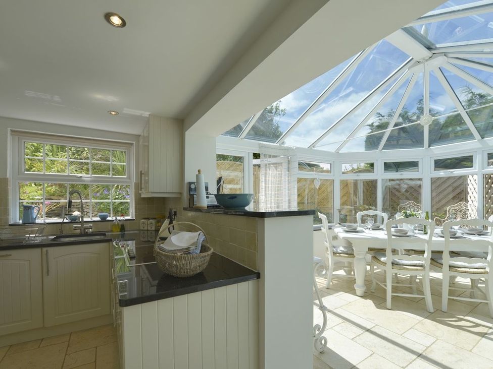 A kitchen with a dining area at Mays Cottage in Wadebridge