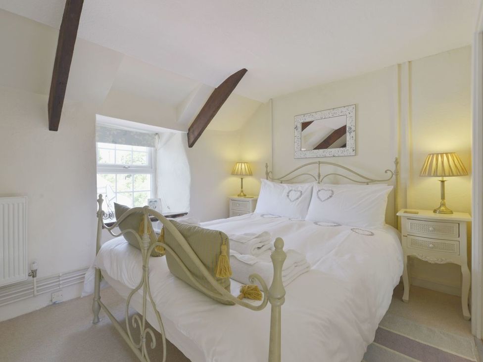 A bedroom with a bed and nightstands at Mays Cottage in Wadebridge