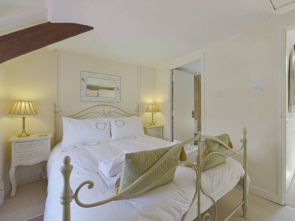 A bedroom with a bed and nightstands at Mays Cottage in Wadebridge