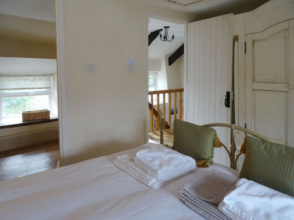 A bedroom with a bed and wardrobe at Mays Cottage Wadebridge
