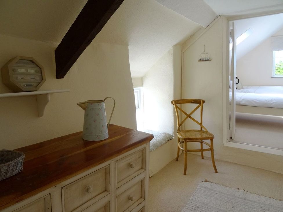 A bedroom with a dresser and a chair at Mays Cottage in Wadebridge