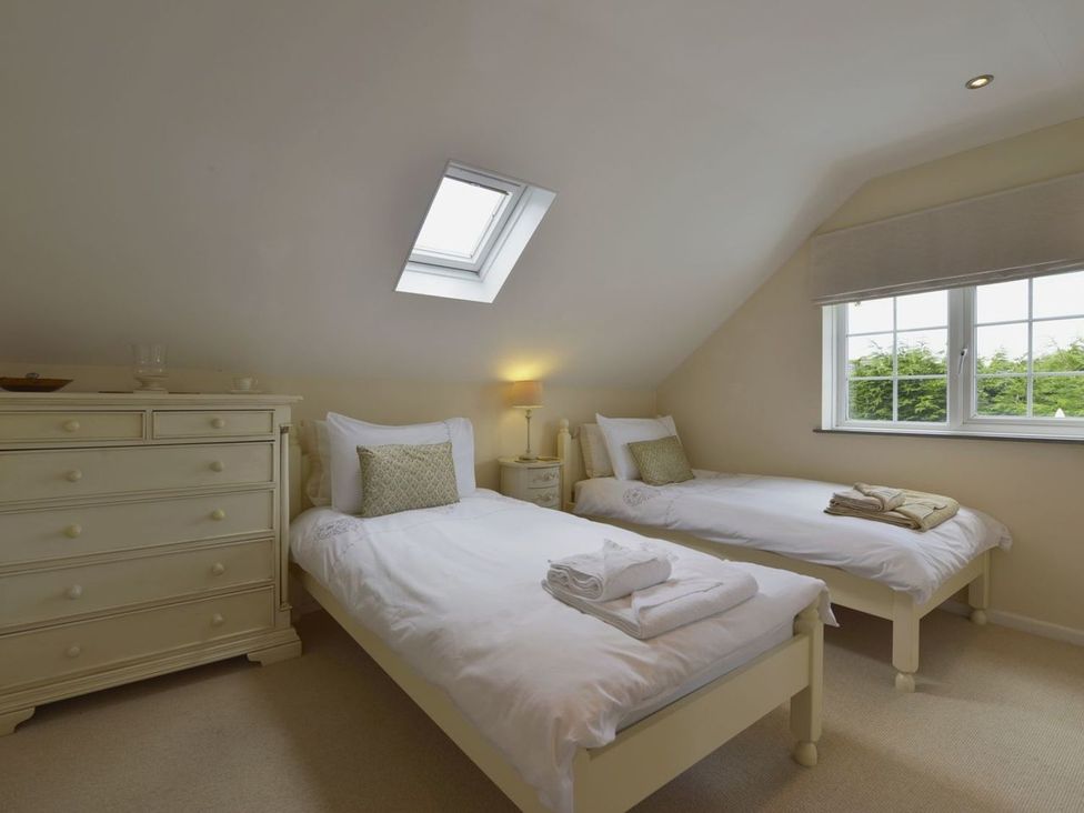 A bedroom with twin beds and a dresser at Mays Cottage in Wadebridge
