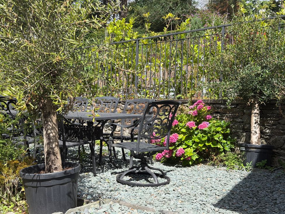 A garden with a table and chairs surrounded by flowers at Kirkstone Brow in Ambleside