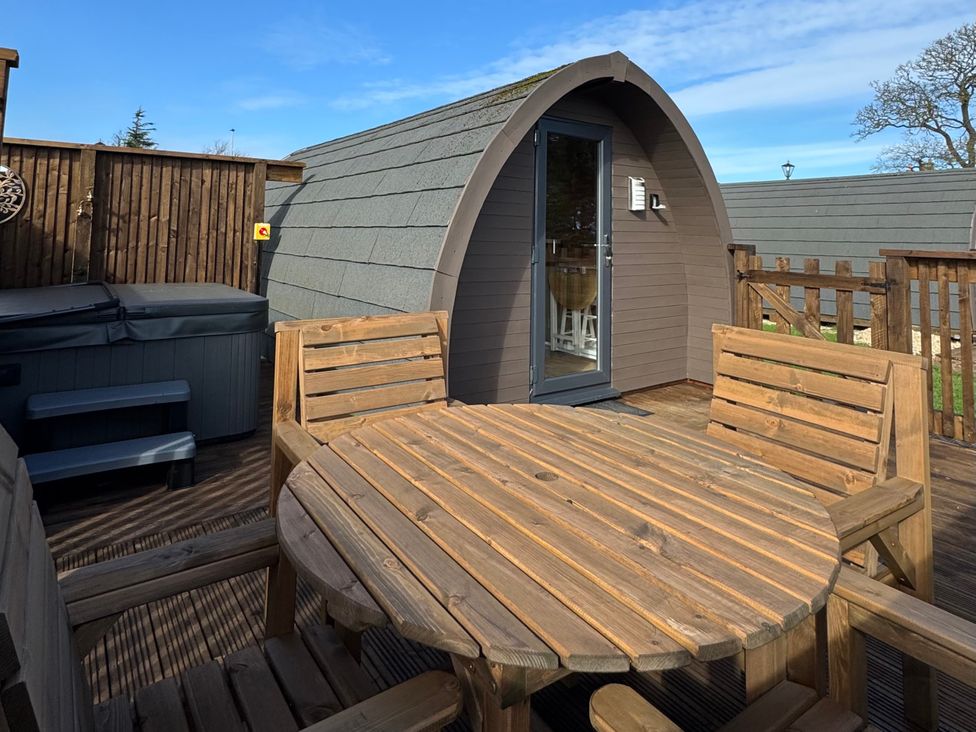An outdoor area with wooden table and chairs at Heather Heights in Whitby