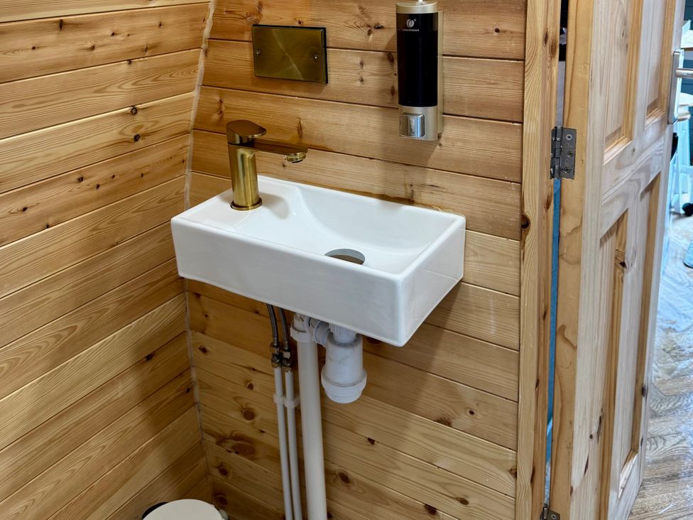 A bathroom with a sink, faucet, and soap dispenser at Heather Heights in Whitby