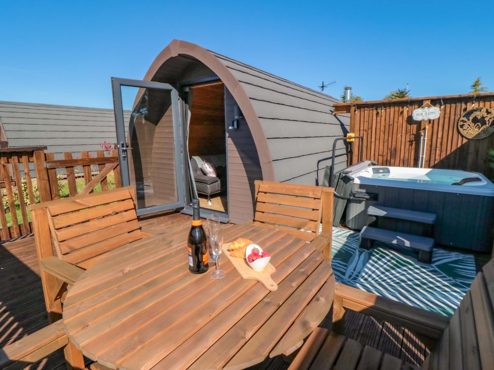 An outdoor area with a hot tub and a wooden table at Rosemary Retreat in Whitby