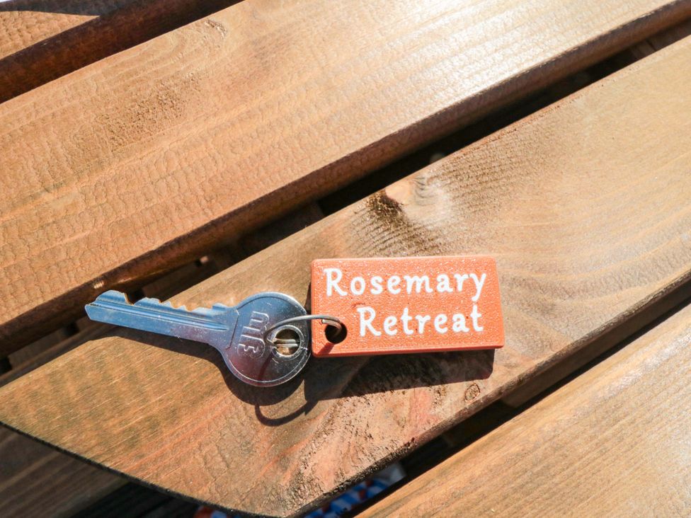 A key and keychain on wooden surface at Rosemary Retreat in Whitby