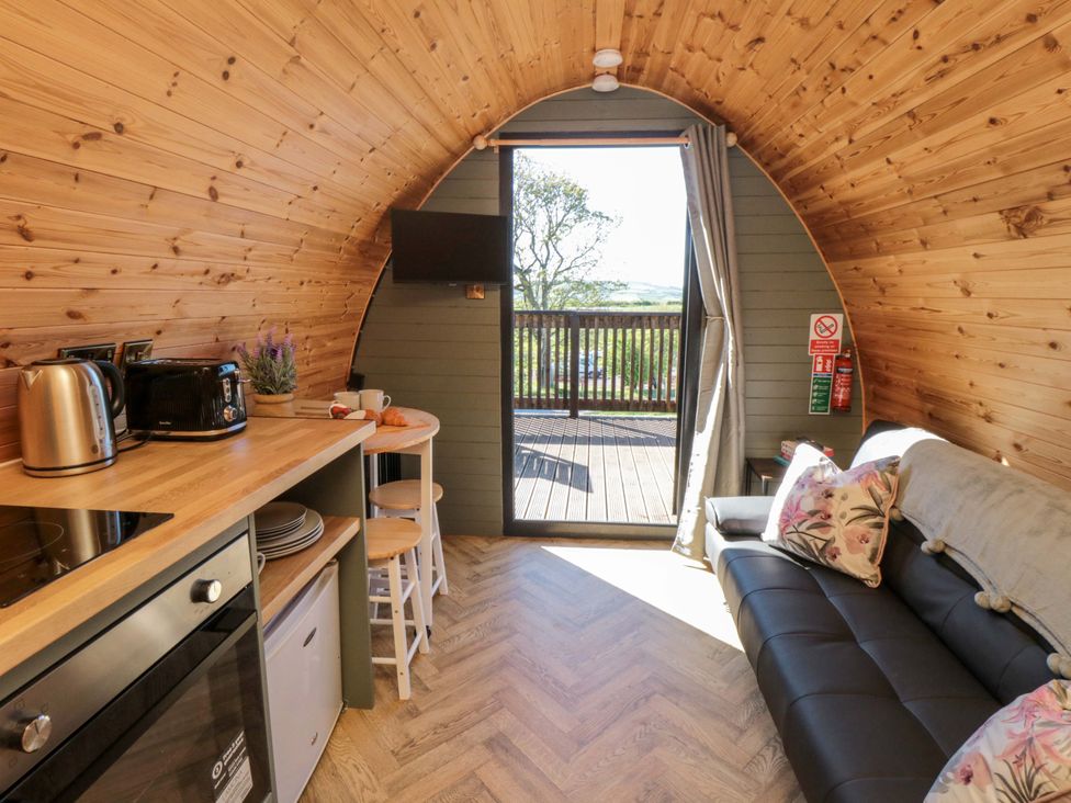 A living room with a couch and kitchenette at Rosemary Retreat in Whitby