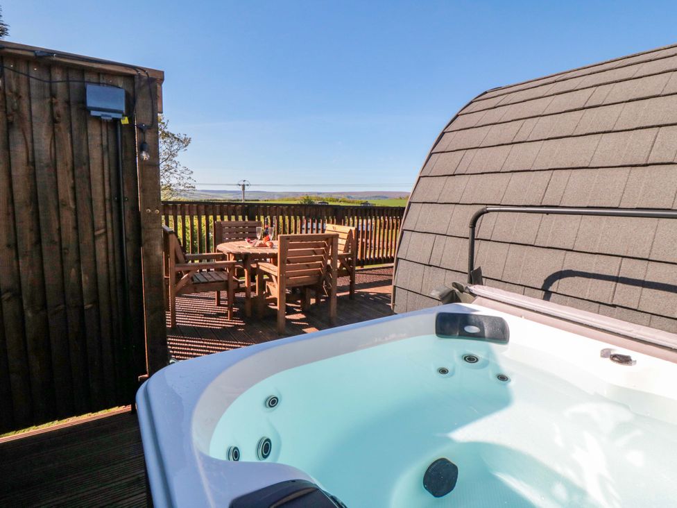 An outdoor area with a hot tub and a table with chairs at Rosemary Retreat in Whitby