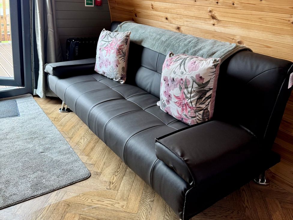 A sofa with cushions and a blanket in the living room at Sage Sanctuary in Whitby