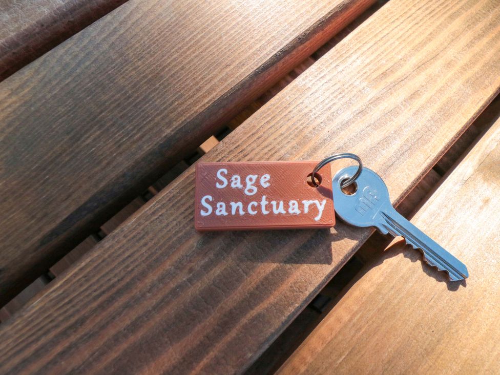 A key and keychain labeled Sage Sanctuary
